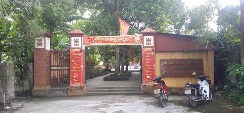 A red archway with a sign and a motorcycle parked in front of it

Description automatically generated